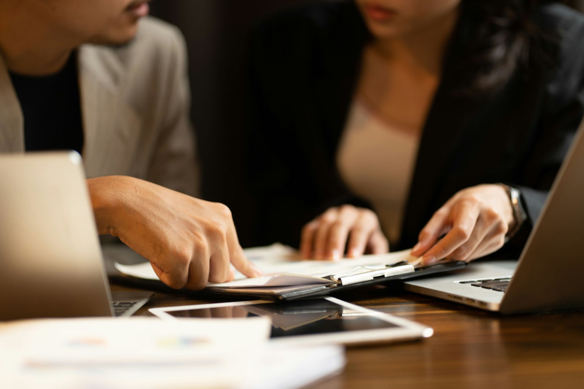 Corporate attorney reviews business documents during a professional client meeting.