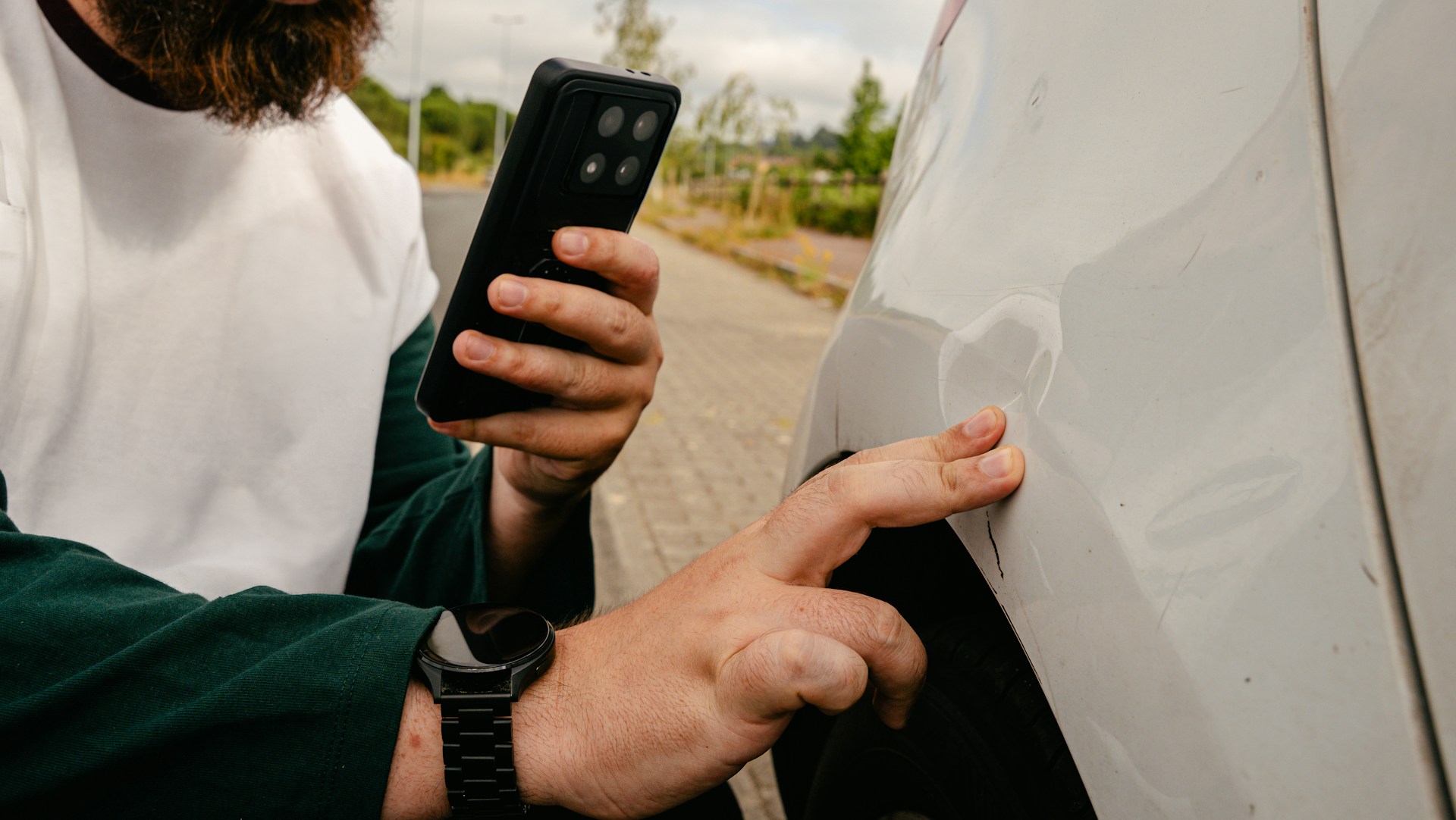 Driver photographs vehicle damage after a minor Florida car accident.